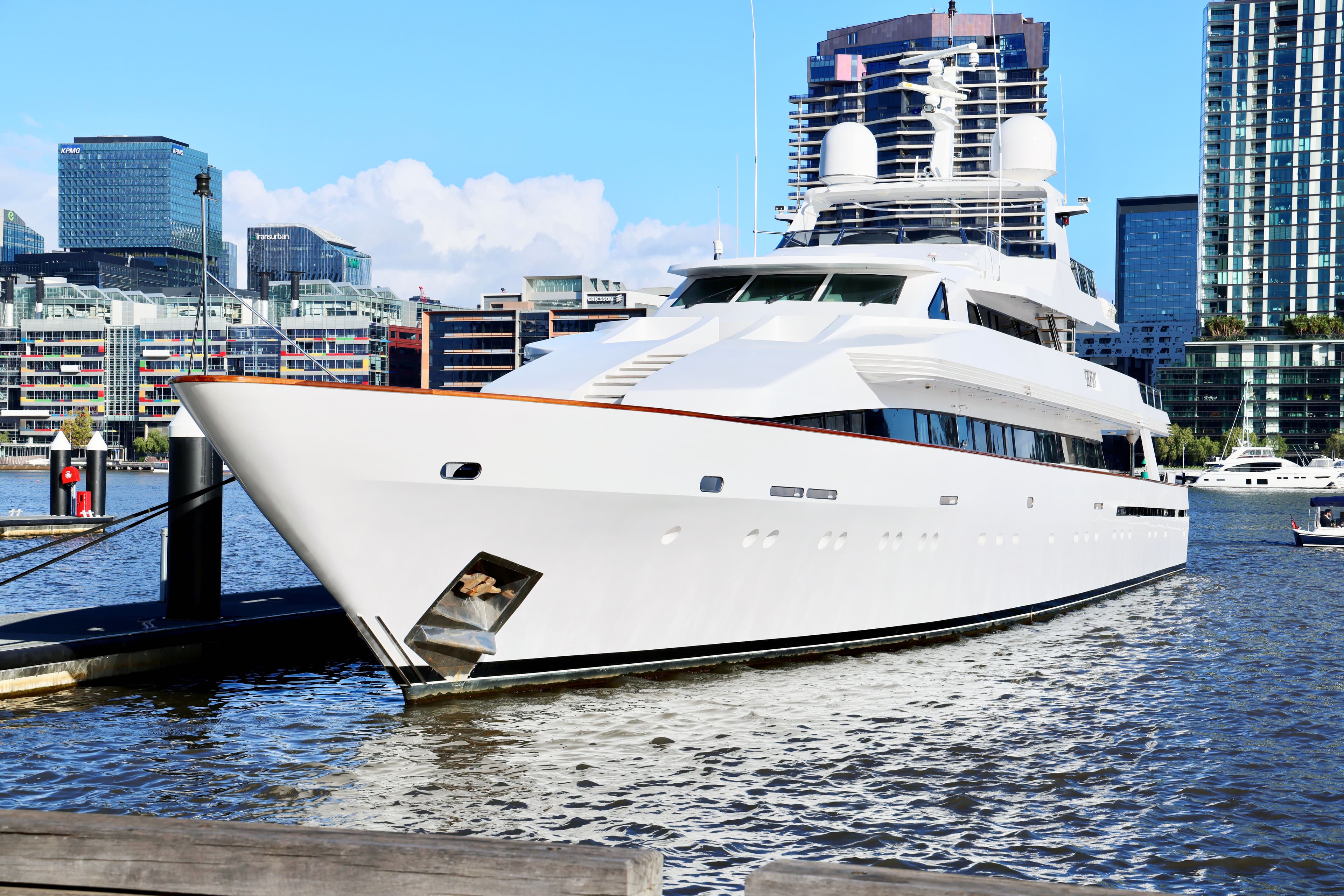 Yacht blanc à quai devant un front de mer urbain